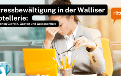 Person in Business-Outfit sitzt an einem Schreibtisch mit Laptop, Kaffeetasse und Schreibutensilien. Text auf dem Bild: ‚Stressbewältigung in der Walliser Hotellerie: Zwischen Gipfeln, Gästen und Gelassenheit‘, Logo ritzy*.