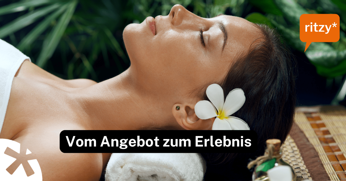 Frau liegt entspannt auf einer Wellnessliege, mit einer Orchideenblüte im Haar, in ruhiger Spa‑Atmosphäre.